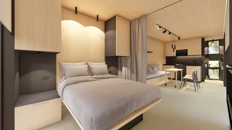 El dormitorio de la cabaña, con el cabecero resuelto dentro de la carpintería de madera clara