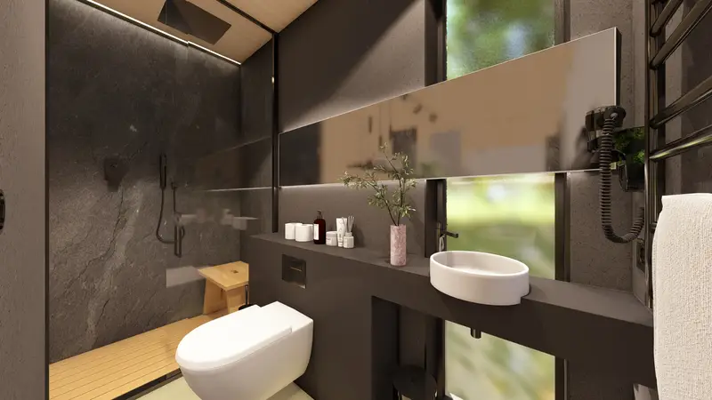 El baño de la cabaña, con lavabo sobre encimera oscura y la ventana alargada al bosque