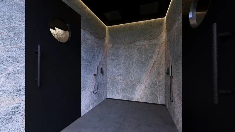 Las duchas del wellness, en piedra oscura, con los ojos de buey del pasillo